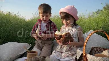 快乐的女孩和男孩吃面包店，可爱的小孩子分享面包，哥哥和姐姐在新鲜空气中玩得开心